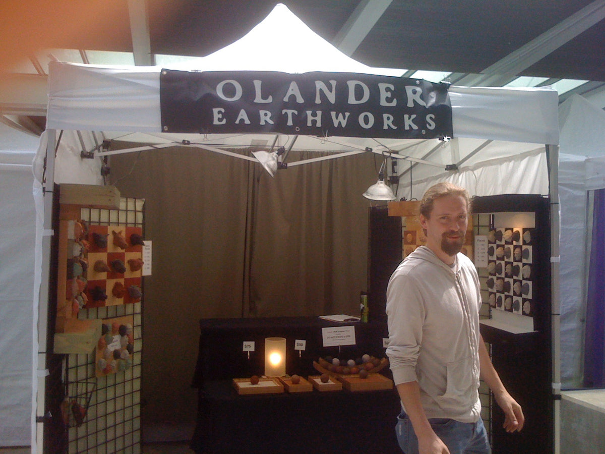 Andrew Lonnquist beside an Olander Earthworks booth at Portland Saturday Market