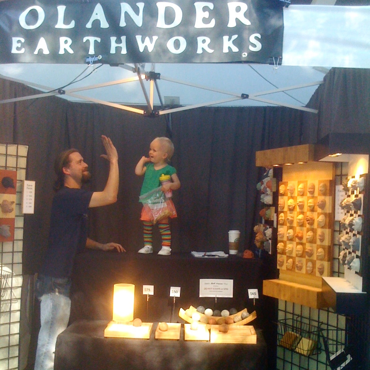 Andrew Lonnquist with his young daughter at an Olander Earthworks market booth