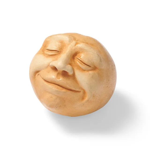 A yellow concrete Glow Tabletop Head with closed eyes and a quiet smile.